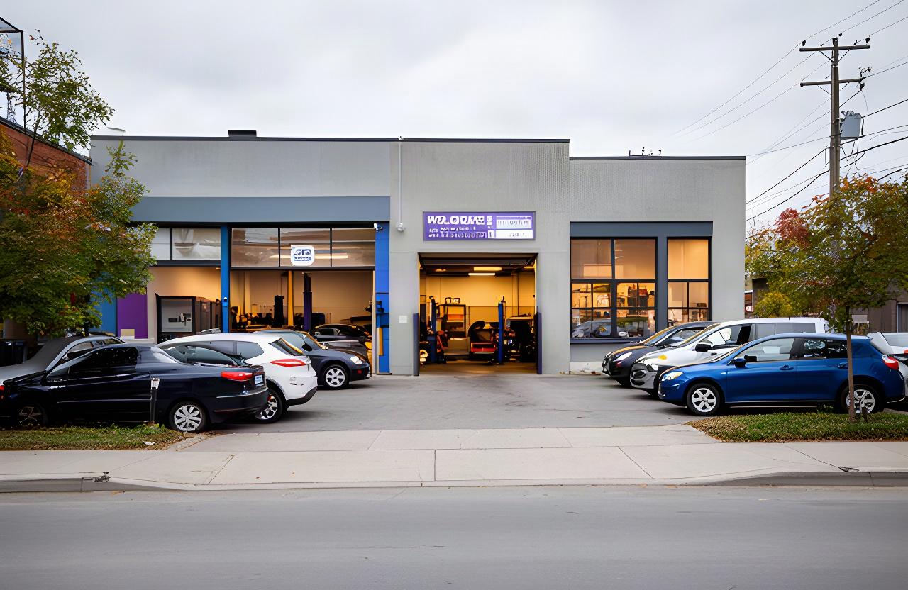 Exterior of an automotive repair shop on a Montreal street with service bays and parked vehicles